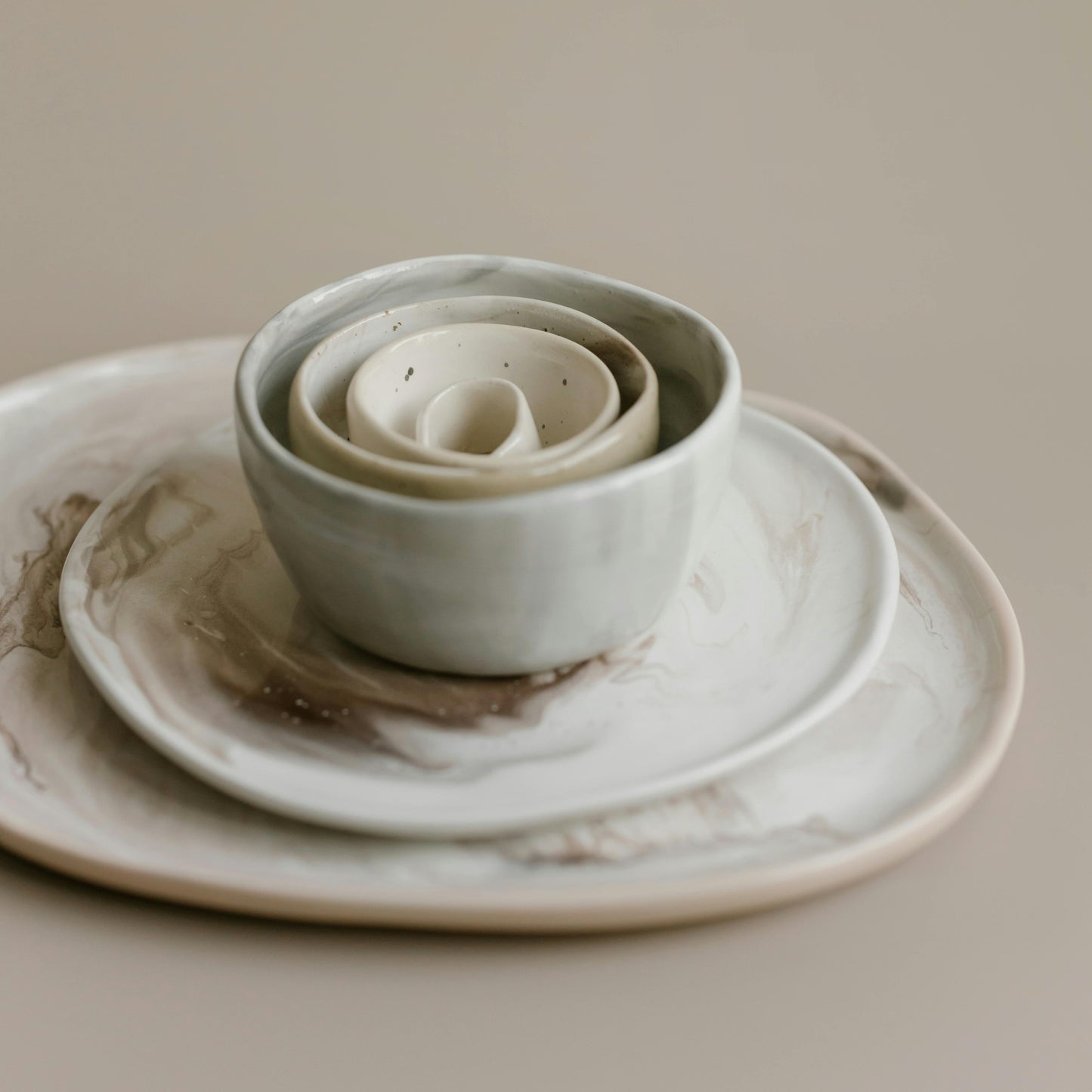 Various irregularly-sized white marbled plates and tea cups